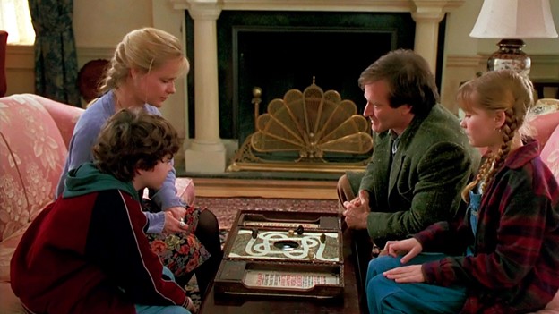 Robin Williams and Kirsten Dunst with the Jumanji board game in Jumanji. Via cosmopolitan.com