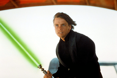 Luke Skywalker with his lightsaber in Star Wars. Via forcematerial.com.